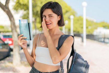 Genç, güzel Bulgar kadın elinde pasaportuyla dışarıda bir şeyler fısıldıyor.