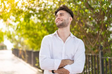 Dışarıdaki yakışıklı adam gülümserken yukarı bakıyor.