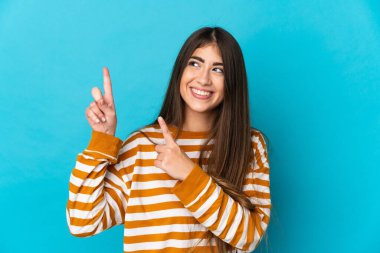 Mavi arka planda izole edilmiş genç beyaz kadın işaret parmağıyla işaret etmek harika bir fikir.