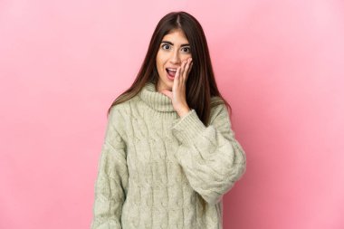 Pembe arka planda izole edilmiş beyaz bir kadın. Şaşırmış ve şok olmuş bir yüz ifadesi var.