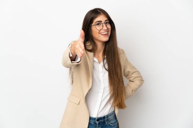 Beyaz arka planda izole edilmiş genç beyaz kadın iyi bir anlaşma için el sıkışıyor.