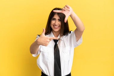 Uçak pilotu sarı arka planda izole edilmiş, odaklanan yüz. Çerçeve sembolü