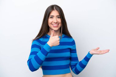 Beyaz arka planda izole edilmiş genç beyaz bir kadın bir ilan vermek ve onaylamak için avucunun içinde hayali bir mekan tutuyor.