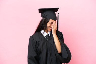 Kolombiyalı genç bir üniversite mezunu pembe arka planda tek başına gülüyor.