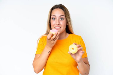 Beyaz arka planda izole edilmiş beyaz bir kadın elinde donut tutuyordu.