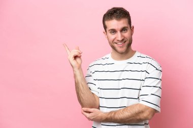 Pembe arka planda izole edilmiş genç, beyaz bir adam.