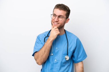 Genç cerrah, beyaz arka planda izole edilmiş beyaz bir adam yan tarafa bakıyor.