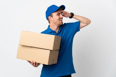 Genç teslimatçı sarışın adam beyaz arka planda izole edilmiş, çok gülümsüyor.