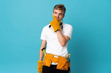 Genç elektrikçi, izole edilmiş duvarın ardında şüpheleri ve kafa karıştırıcı yüz ifadesiyle.