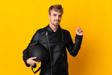 Motosiklet kasklı bir adam sarı arka planda izole edilmiş.