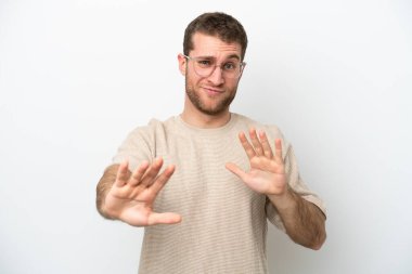 Beyaz arka planda izole edilmiş genç beyaz bir adam sinirleri gergin ve ellerini öne uzatıyor.