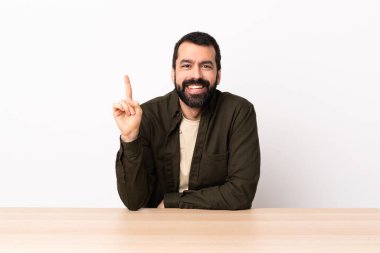 Masada sakallı beyaz bir adam harika bir fikri işaret ediyor..