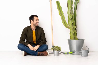 Bahçıvan yerde oturuyor, içeri bakıyor.