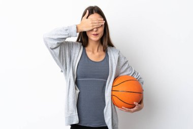 Basketbol oynayan genç bir kadın beyaz arka planda izole edilmiş, gözleri elle kapatıyor. Bir şey görmek istemiyorum.