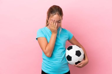 Küçük futbolcu kız pembe arka planda izole edilmiş, yorgun ve hasta bir ifadeyle.