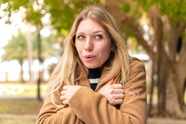 Açık havada donmakta olan güzel sarışın kadın.