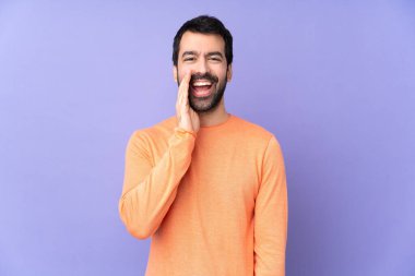 Mor arka planda beyaz, yakışıklı bir adam ağzı açık bağırıyor.