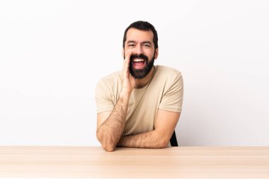 Masada sakallı, ağzı açık bağıran beyaz bir adam..