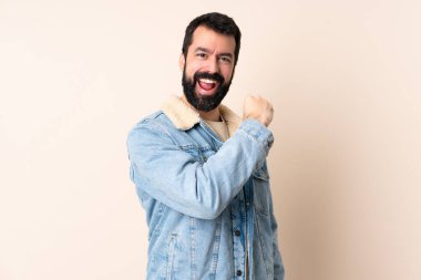 Sakallı beyaz bir adam tecrit edilmiş arka planda zaferi kutluyor.