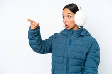 Beyaz arka planda izole edilmiş, kış kulaklığı takan genç İspanyol kadın.