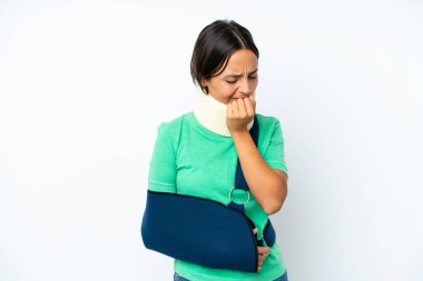 Young hispanic woman wearing a neck brace and sling isolated on white background having doubts