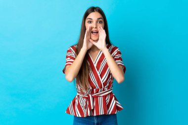 Beyaz bir kadın mavi arka planda izole edilmiş bağırıyor ve bir şeyler söylüyor.