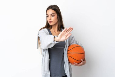 Beyaz arka planda basketbol oynayan genç bir kadın dur hareketi yapıyor ve hayal kırıklığına uğruyor.