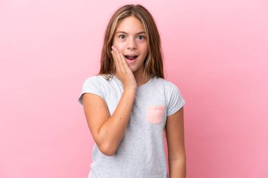 Küçük beyaz kız pembe arka planda izole edilmiş, şaşırmış ve şok olmuş bir yüz ifadesi var.