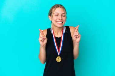 Mavi arka planda madalyaları olan genç beyaz bir kadın.