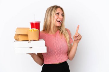 Mavi arka planda yağlı yiyecekler taşıyan beyaz bir kadın harika bir fikre işaret ediyor.