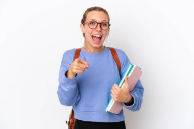 Beyaz arka planda izole edilmiş genç beyaz kadın şaşırmış ve ön tarafı işaret ediyor.