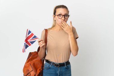 Beyaz arka planda izole edilmiş bir Birleşik Krallık bayrağı tutan genç sarışın kadın sağa bakarken şaşırmış ve şok olmuştu.