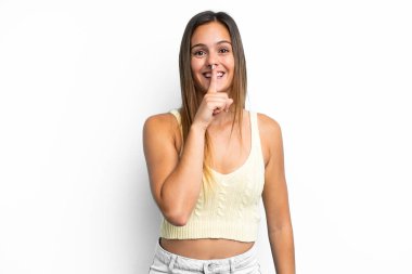 Beyaz arka planda izole edilmiş beyaz bir kadın sessiz bir jest işareti gösteriyor. Parmağını ağzına sokuyor.