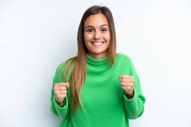 Beyaz arka planda izole edilmiş genç beyaz kadın galibiyeti kutluyor.