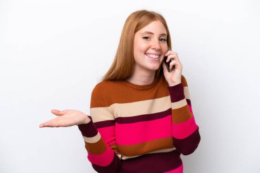 Beyaz arka planda izole edilmiş genç, kızıl saçlı bir kadın cep telefonuyla sohbet ediyor.