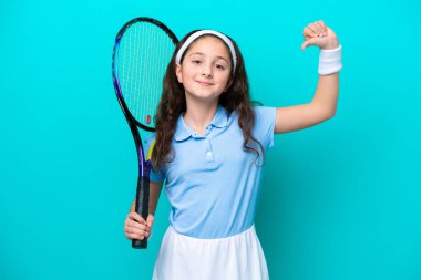 Tenis oynayan küçük beyaz kız mavi arka planda soyutlanmış gururlu ve kendini beğenmiş.