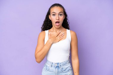 Mor arka planda izole edilmiş genç bir kadın sağa bakarken şaşırmış ve şok olmuştu.