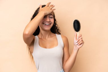 Bej arka planda saç tarağı olan genç İspanyol kadın bir şey fark etti ve çözüme niyetlendi.