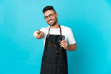 Önlüklü berber mutlu bir ifadeyle öne bakıyor.