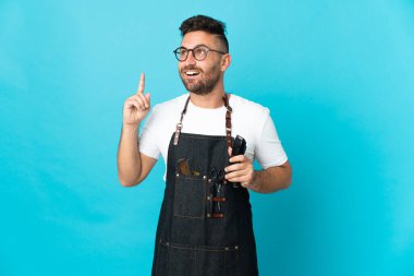 Önlüklü bir berber parmağıyla işaret etmeyi düşünüyor.