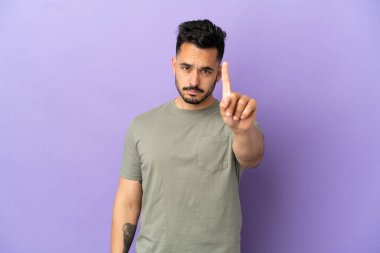 Mor arka planda izole edilmiş beyaz bir adam ciddi bir ifadeye sahip birini sayıyor