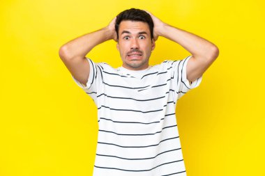 Young handsome man over isolated yellow background doing nervous gesture
