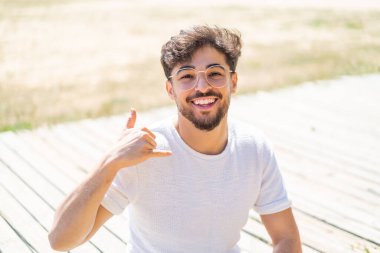 Dışarıdaki yakışıklı Arap gözlüklü ve telefon hareketleriyle