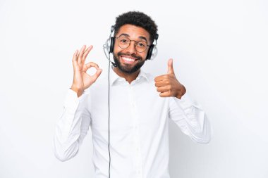 Tele pazarlamacı Brezilyalı adam beyaz arka planda izole edilmiş bir kulaklıkla çalışıyor.