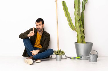 Bahçıvan içeride oturmuş ciddi bir ifadeye sahip birini sayıyor.