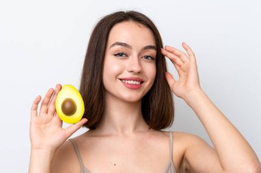 Genç Ukraynalı bir kadın beyaz arka planda izole edilmiş, elinde avakado tutarken gülümsüyor. Portreyi kapat