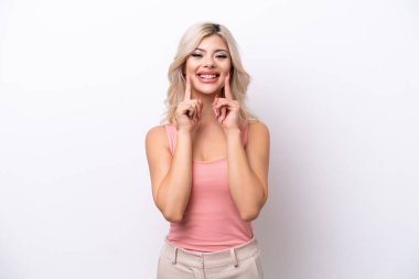 Beyaz arka planda izole edilmiş genç bir Rus kadın mutlu ve hoş bir ifadeyle gülümsüyor.