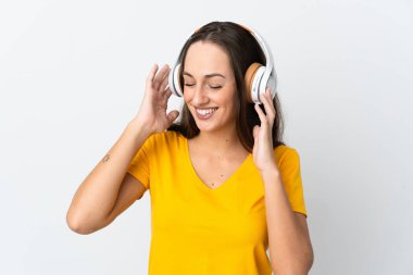 Soyutlanmış beyaz arka planda genç İspanyol kadın müzik dinliyor.