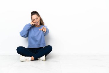 Telefon jest yapma ve açık işaret katta oturan genç kadın