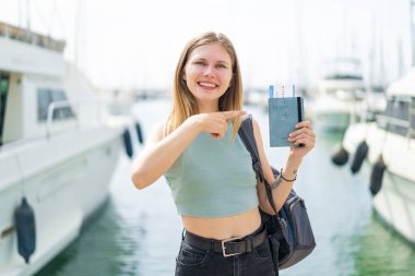 Açık havada pasaportu olan genç sarışın bir kadın.